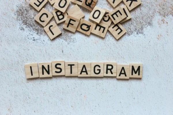 Wooden letter blocks arranged to spell 'Instagram' on a textured surface.
